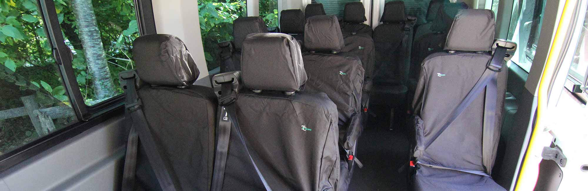 Interior of a minibus with Black seat covers on seats.