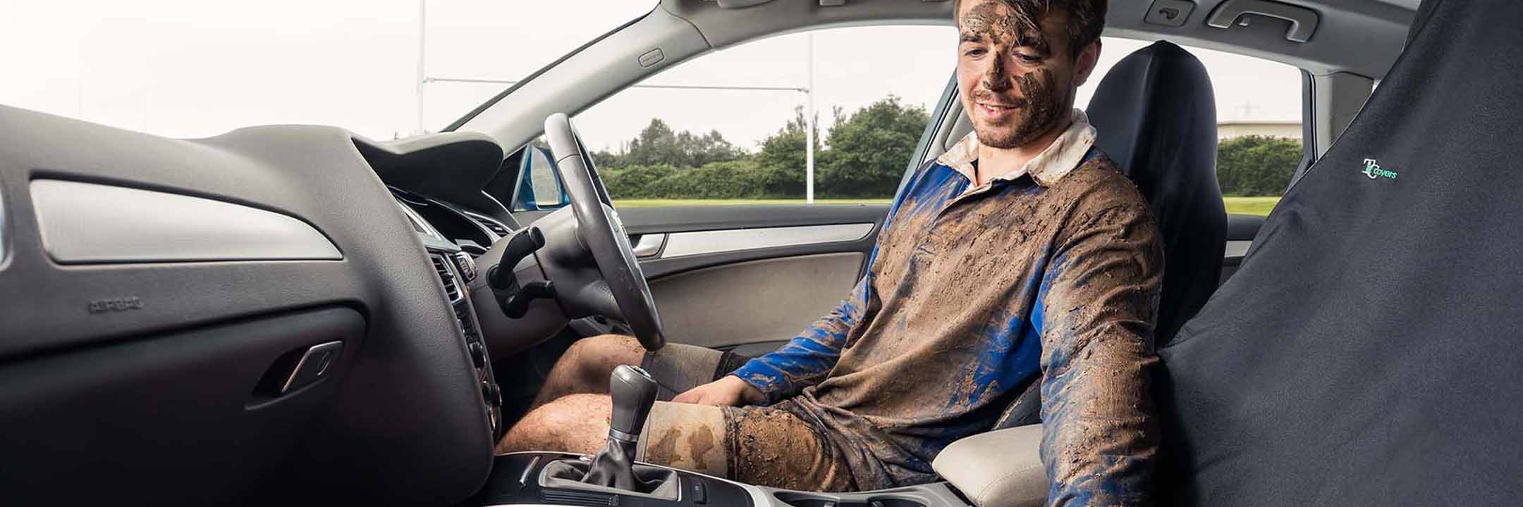 A man covered in mud sitting on universal car seat covers