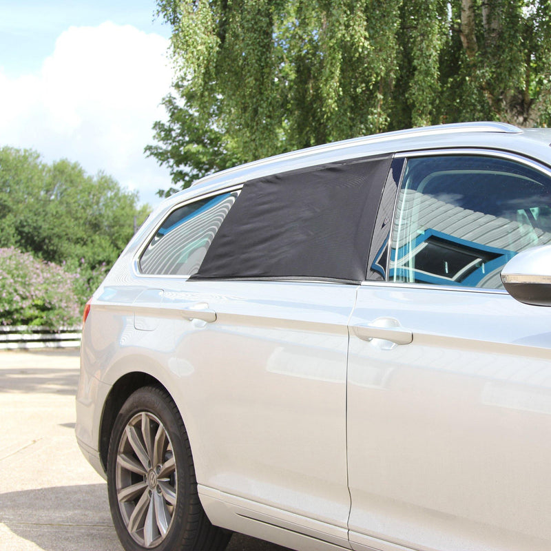 Sun shinding down onto baby car sun shade on rear window of silver estate car